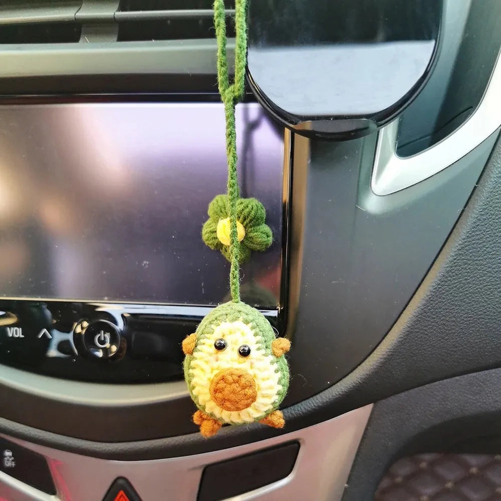 Handmade crocheted car pendant with avocado and rainbow colours hanging from rear-view mirror