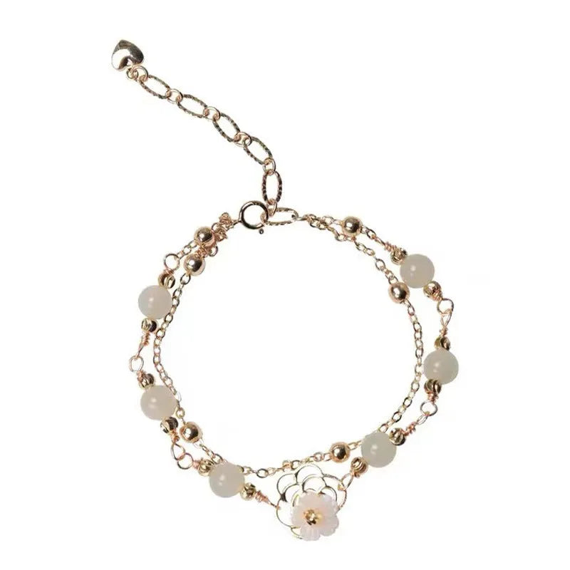 Yellow gold electroplated copper bracelet with a geometric bells of Ireland butterfly and Hetian jade design for women.