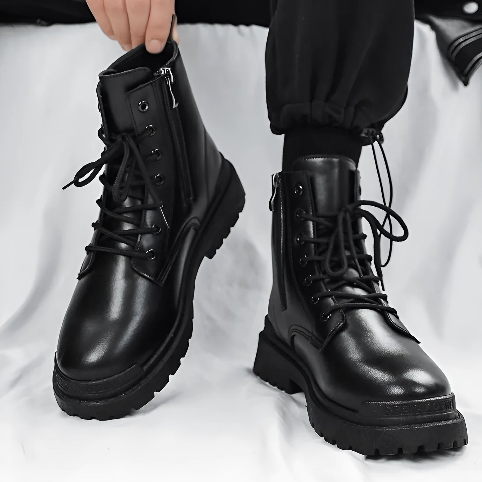 Men's black mid-top leather-style boots with rubber sole showing waterproof non-slip design