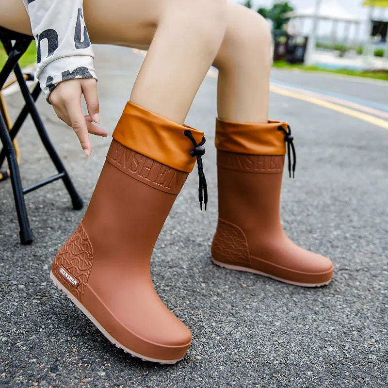 Women's solid colour PVC rain boots with non-slip sole in apricot, black, brown, or pink.