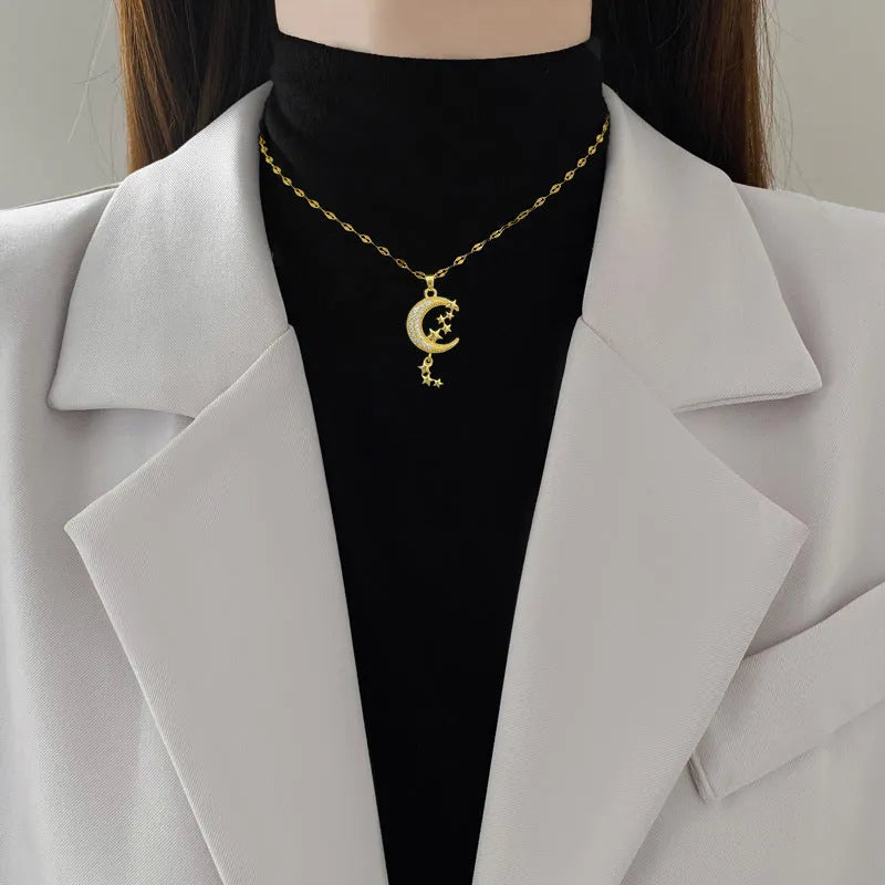 Moon-themed necklace with geometric copper pendant featuring tassel and diamond details on stainless steel chain