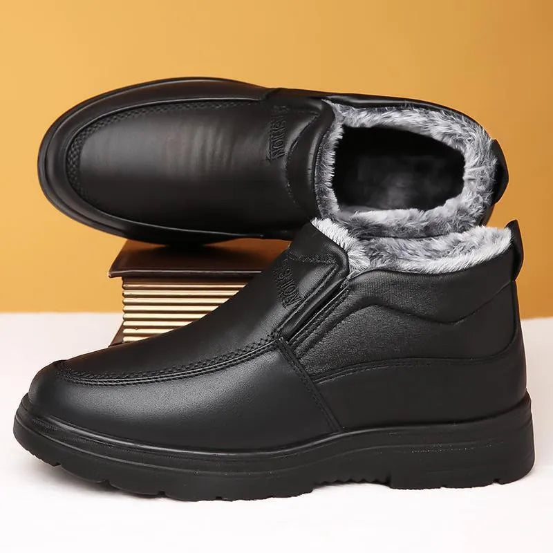 Men's black fleece-lined winter slip-on shoes with rubber sole on a wooden floor.
