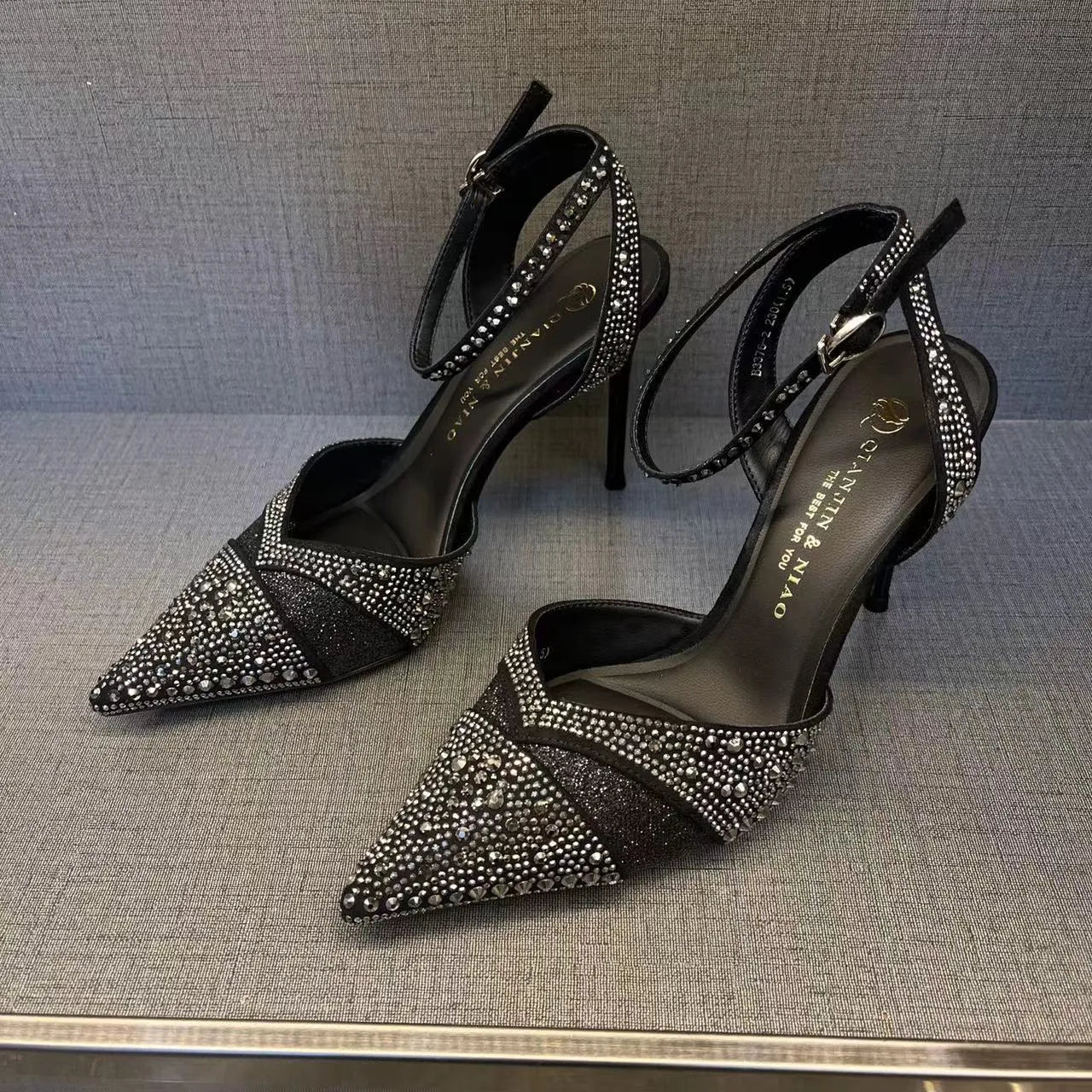 Women's black and silver hollow high heels with red stiletto soles and pointed toes.