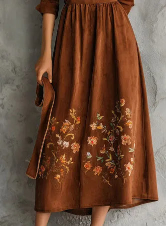 Brown polyester midi dress with floral embroidery detail and long sleeves on a hanger.