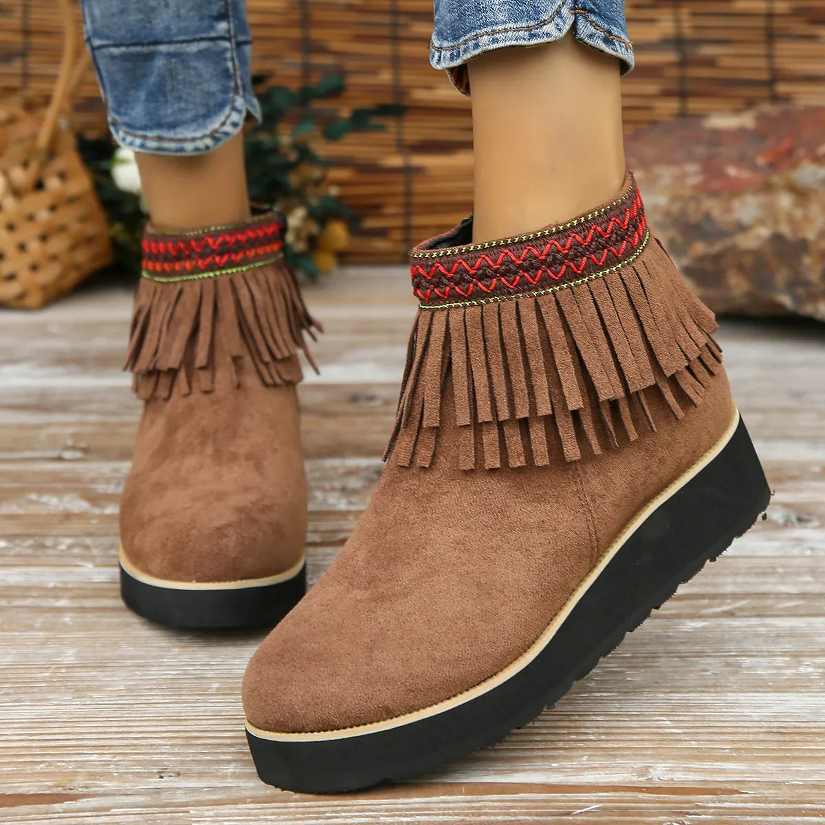 Women's dark brown suede wedge bootie with thick sole, side zipper, and tassel detail.