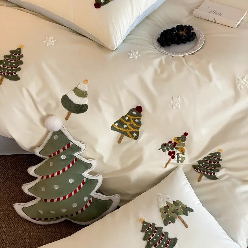 Cream blue Christmas tree embroidered pure cotton duvet cover, flat sheet, and pillowcases on a bed.
