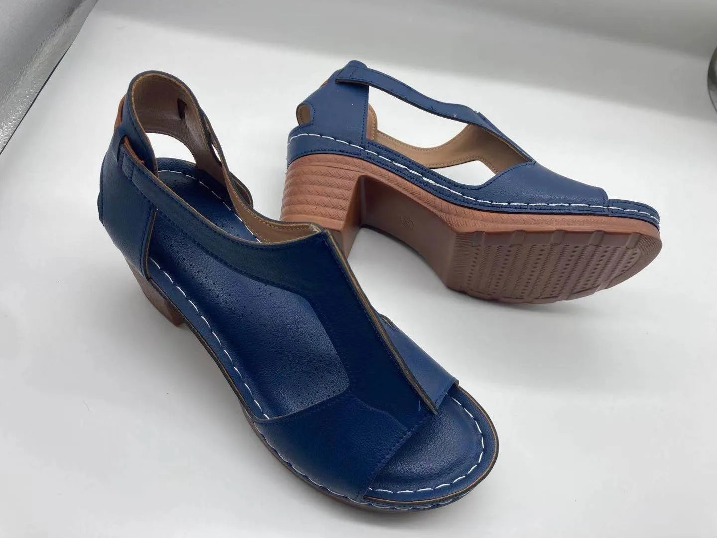Plus size women's beige open toe wedge sandals with a buckle strap and low heel on a white background.