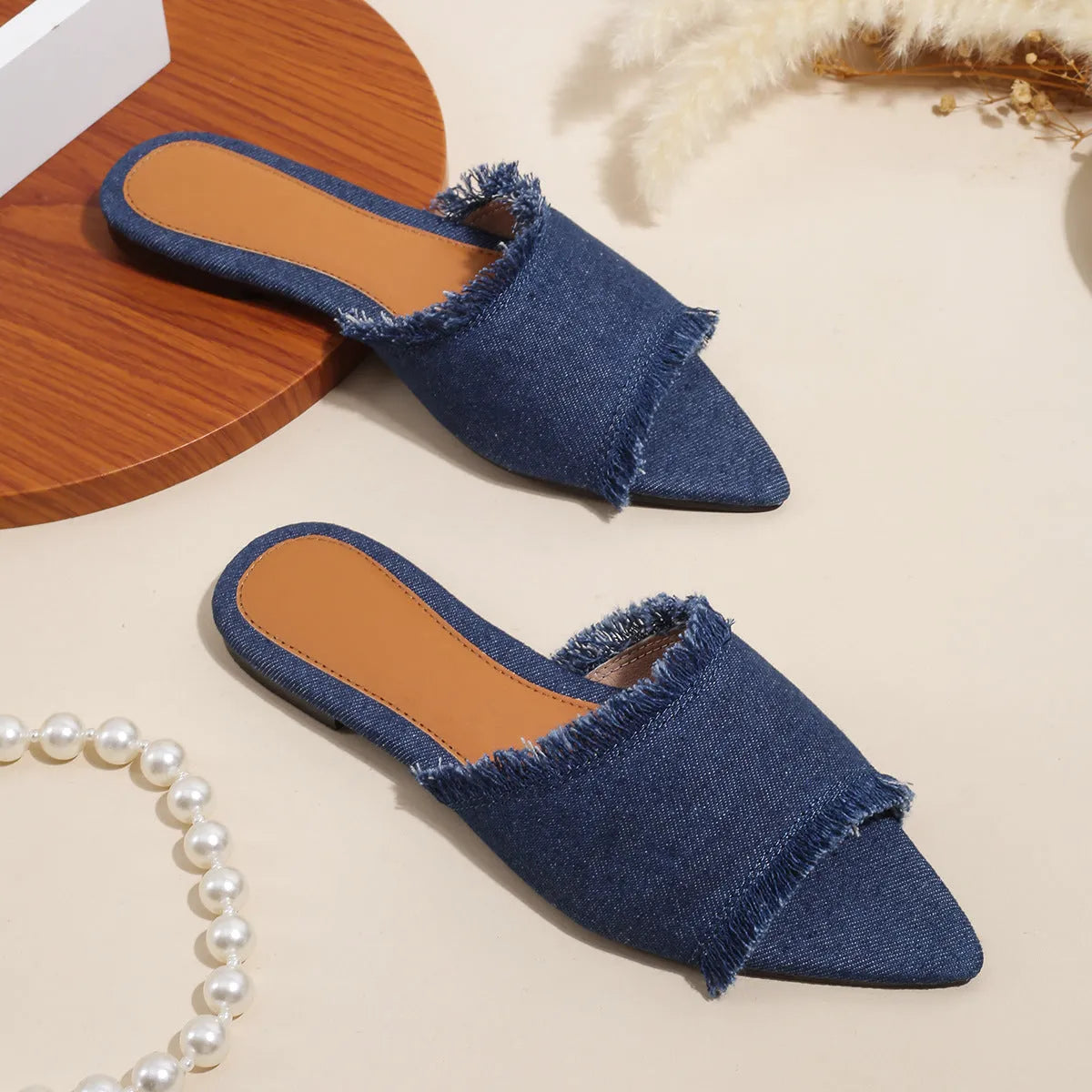 Women's denim flat slippers with tassel detail and leather lining in various colours.