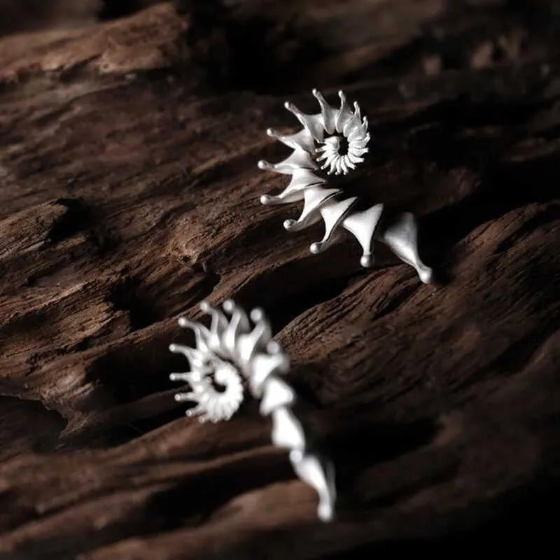 A pair of matte conch-coloured alloy stud earrings with an exaggerated three-dimensional shape.