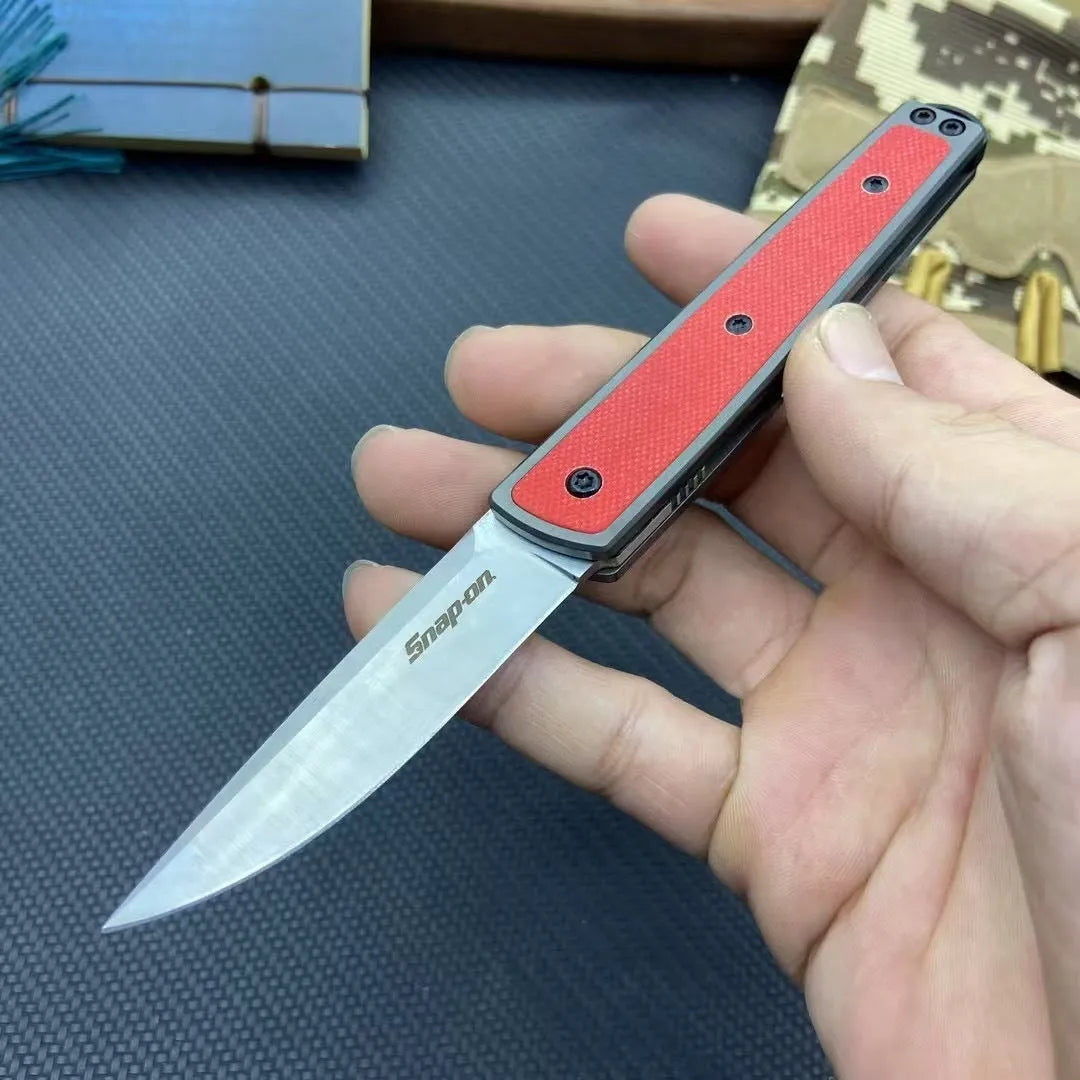 Closed and open views of a black folding fruit knife showing blade and handle.