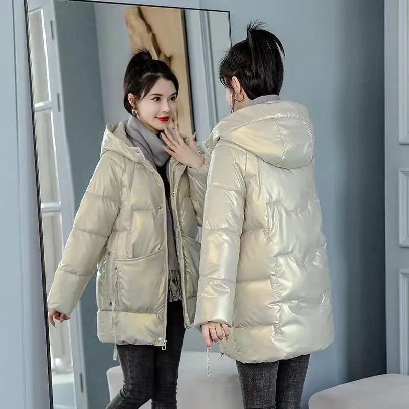 A woman wears a loose-fitting green hooded winter jacket with long sleeves.