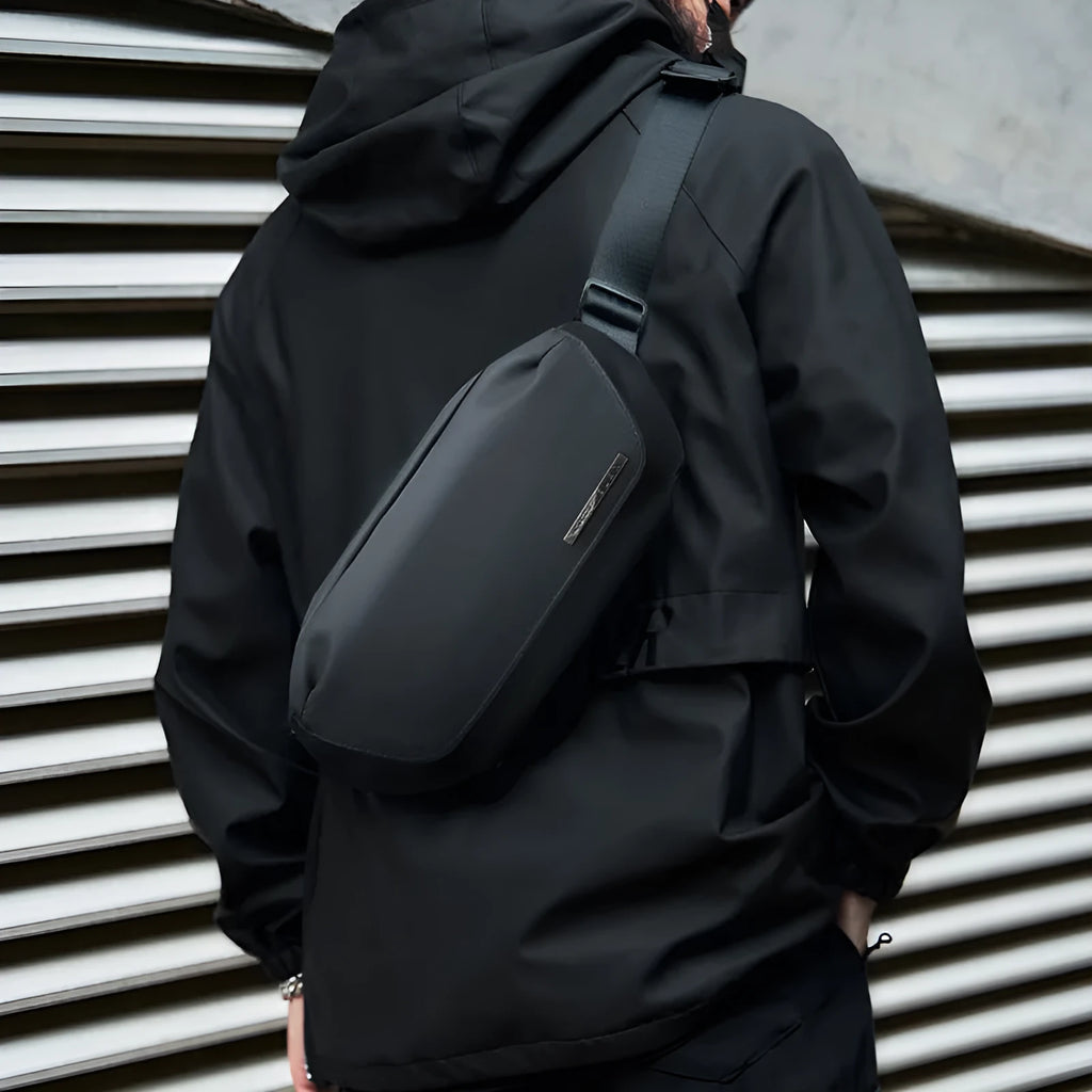 Black men's Oxford cloth messenger bag shown as a crossbody bag.
