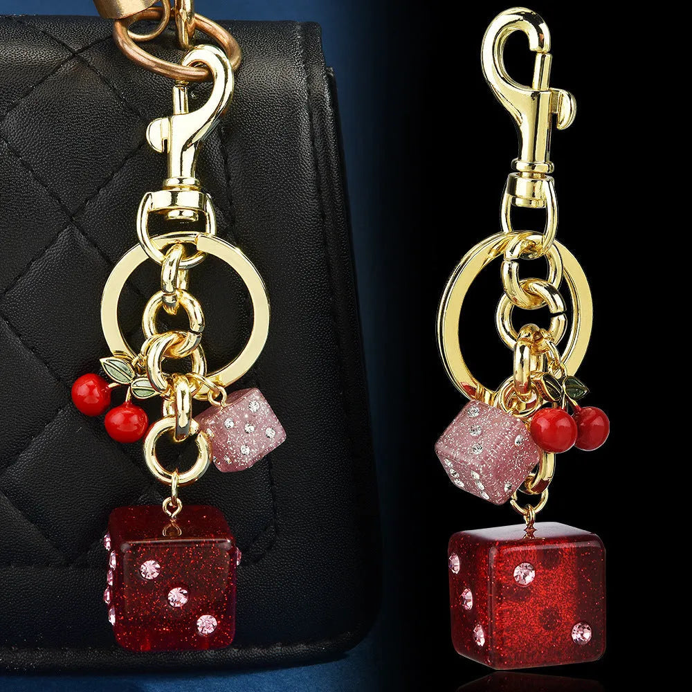 Vintage cherry two-tone dice design on a square electroplated metal keychain pendant.