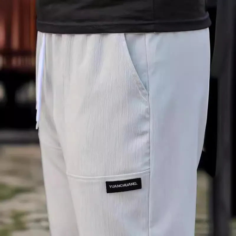 Men's light grey polyester trousers for spring and autumn casual wear, shown in Asian sizing.