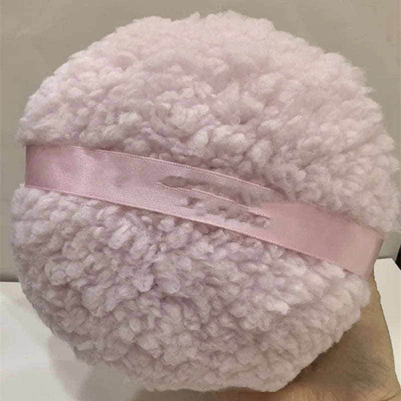 Oversized plush dry powder puff measuring 150x75mm for loose powder application in white skin colour