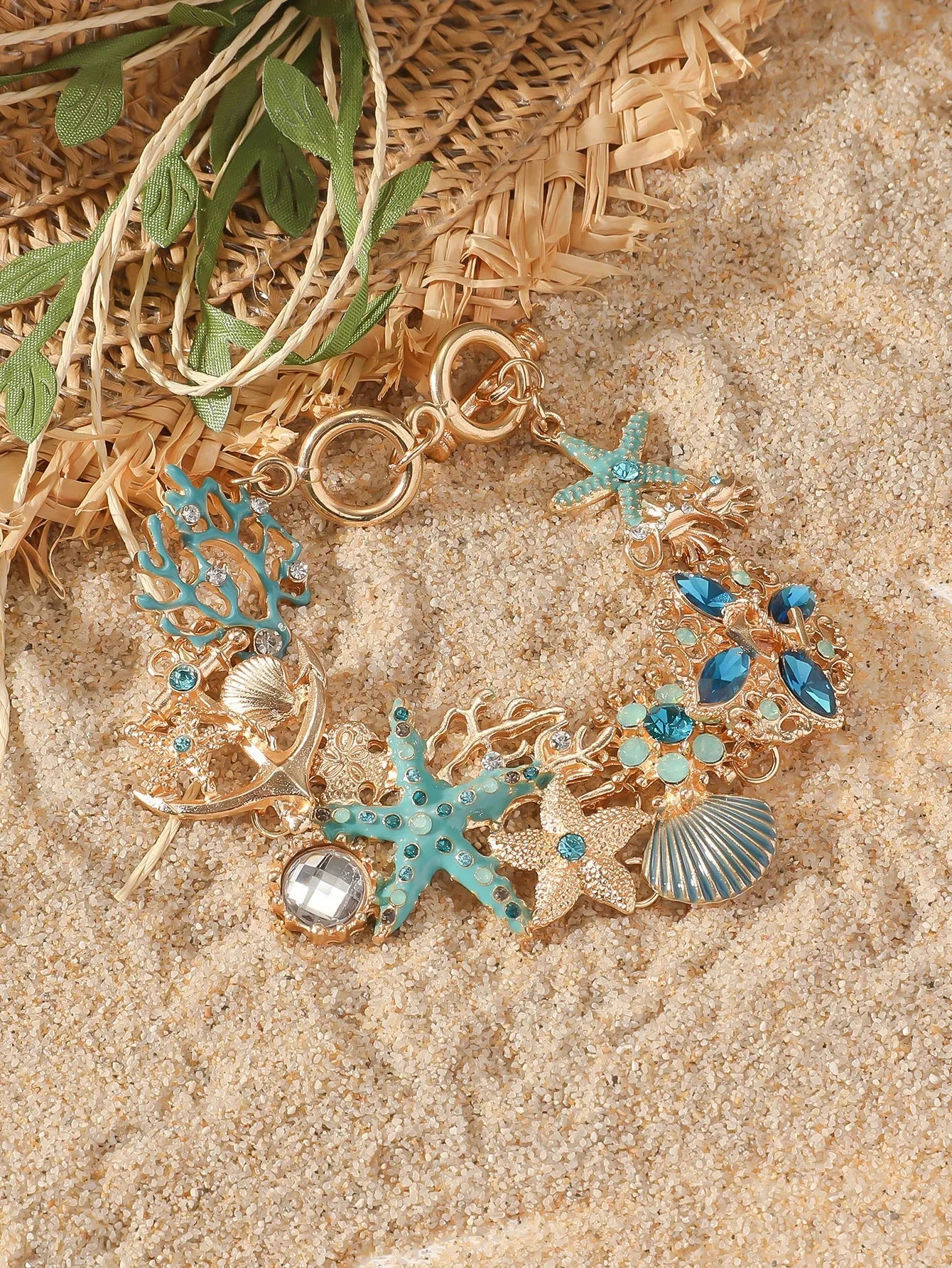 Women's alloy rhinestone bracelet with boat anchor, shell, and starfish charms in blue.