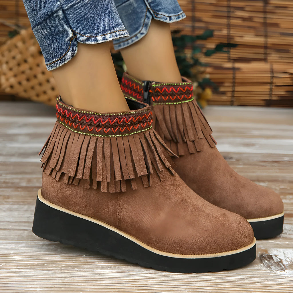 Women's dark brown suede wedge bootie with thick sole, side zipper, and tassel detail.