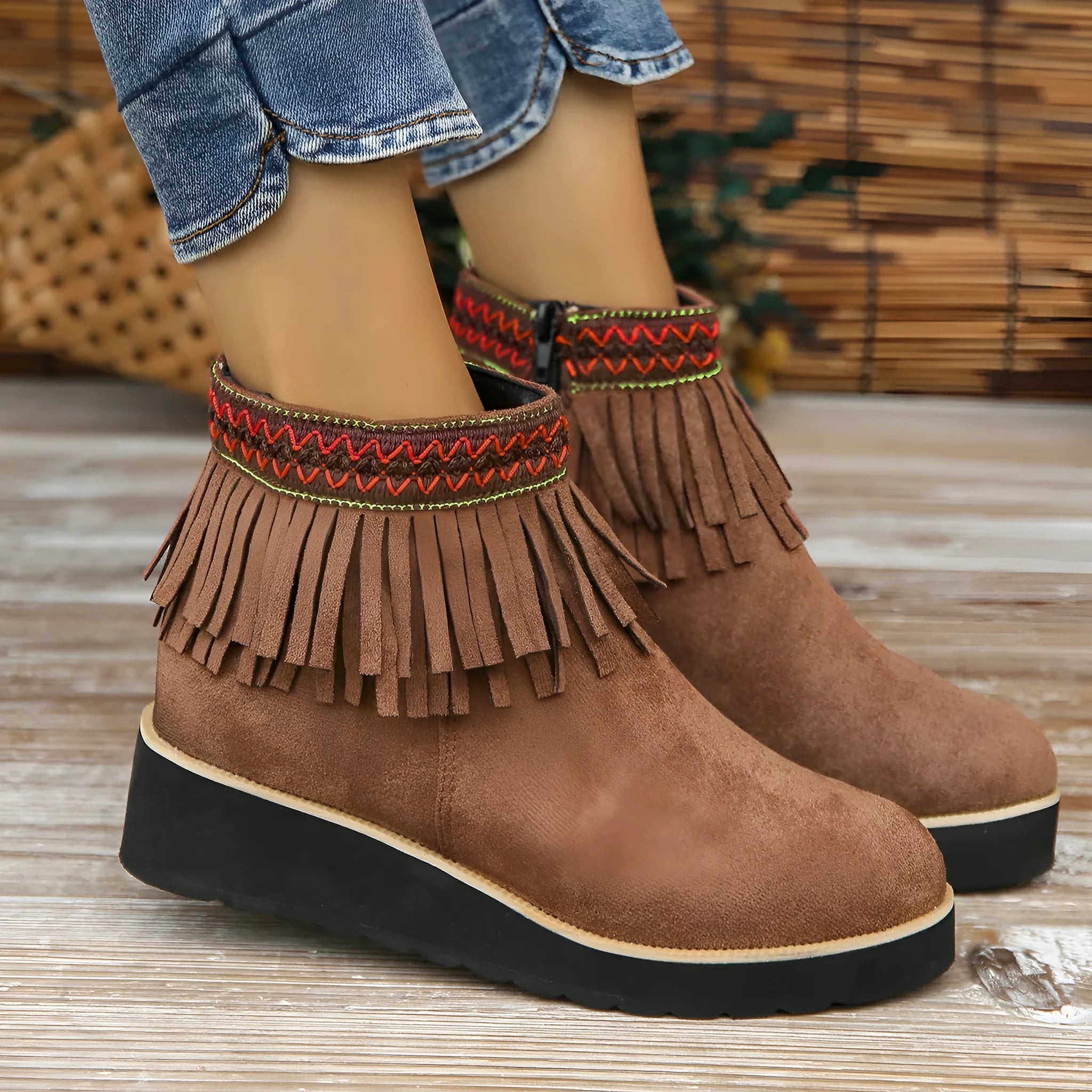 Women's dark brown suede wedge bootie with thick sole, side zipper, and tassel detail.