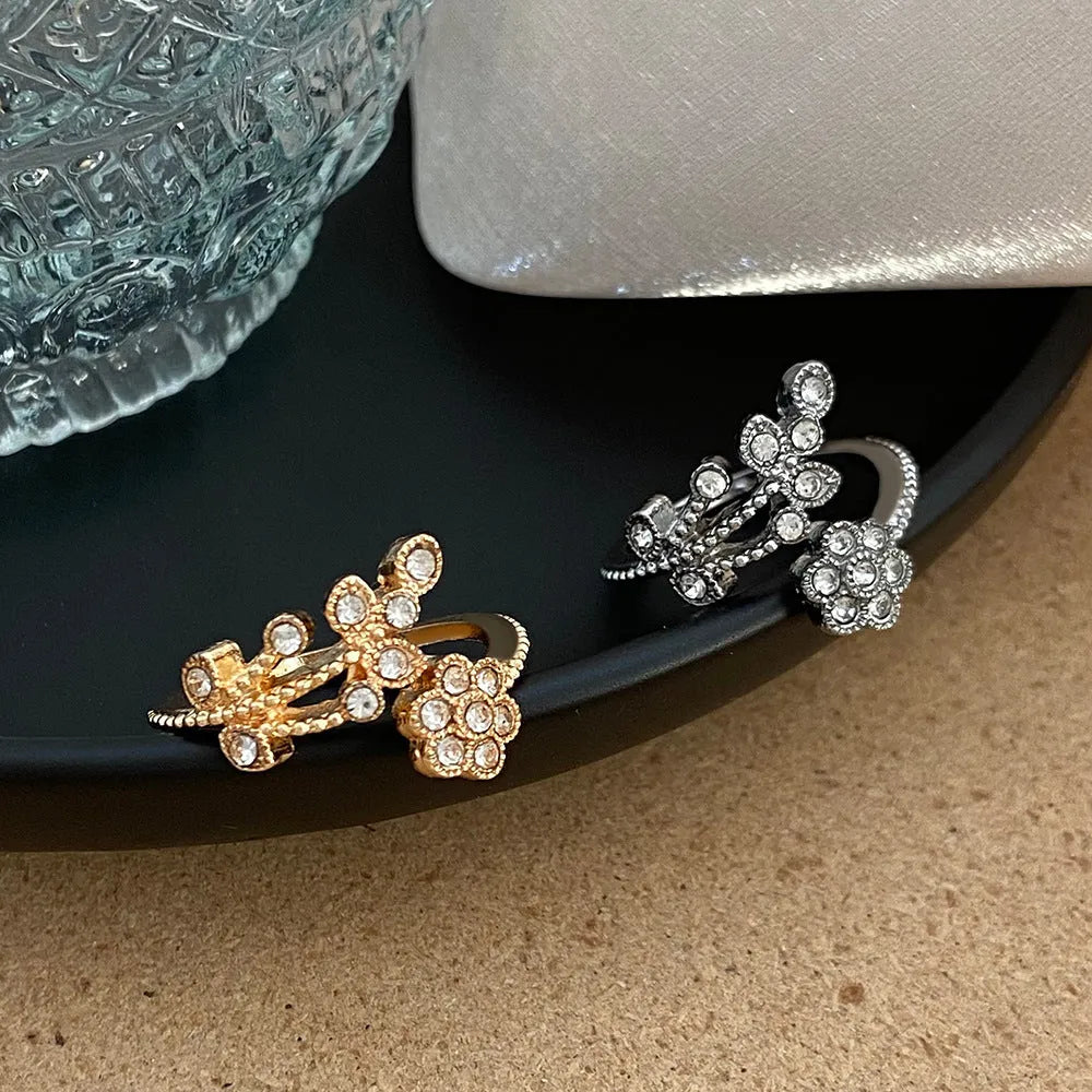 Women's open copper ring with diamond-treated floral and leaf design in gold colour.