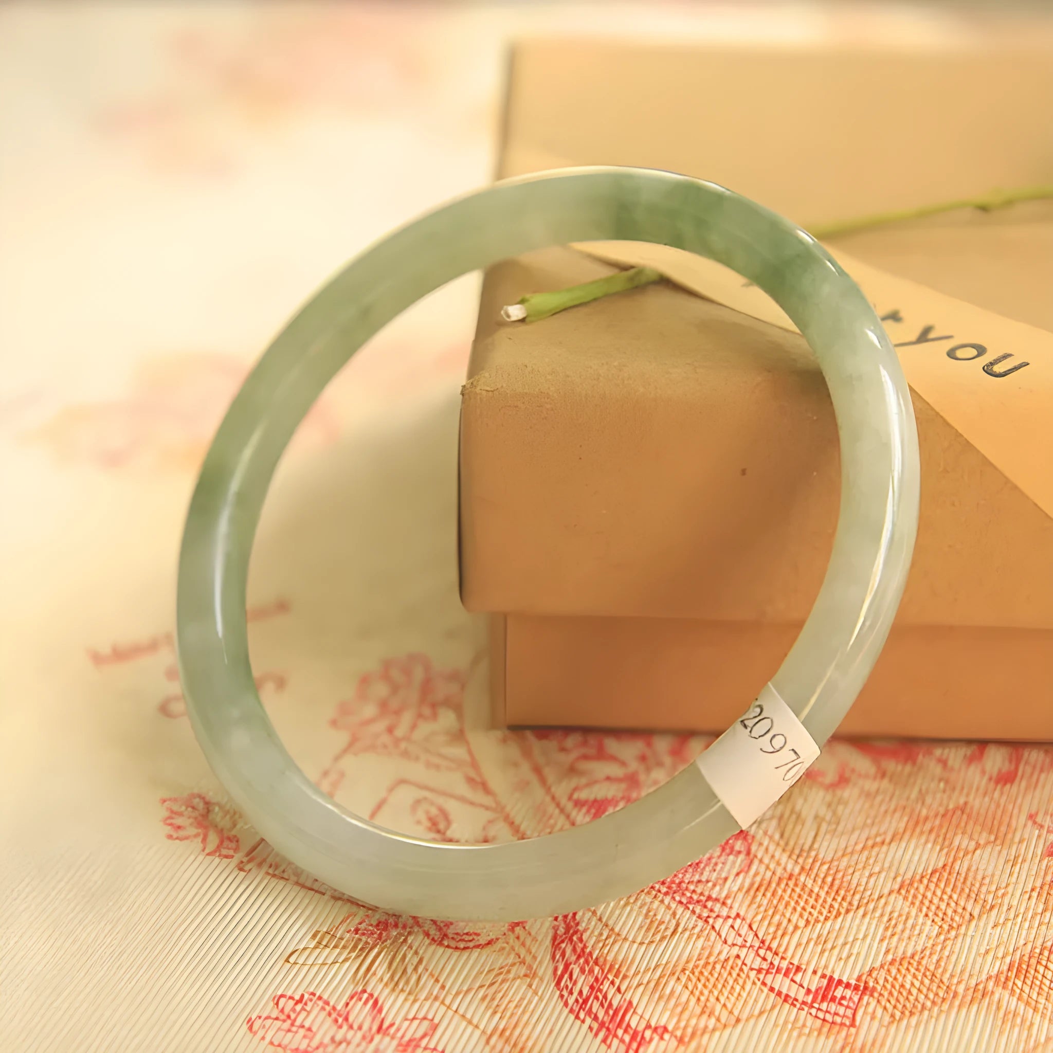 Green jade waxy geometric bead bracelet with adjustable cord on a plain background.