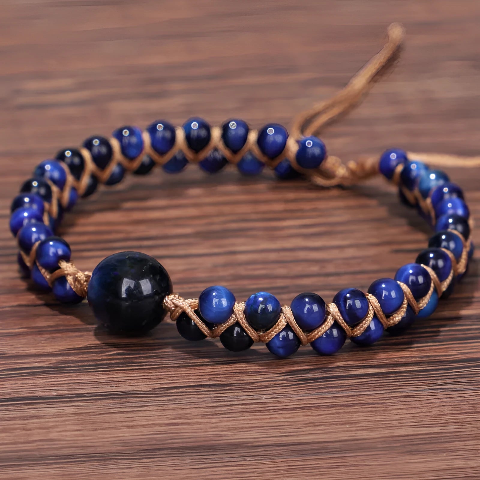 Handmade woven bracelet with geometric pattern in blue tigereye stone beads and pull closure.