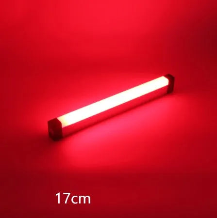 Blue and purple rechargeable LED tube light with USB cable on a dark background.