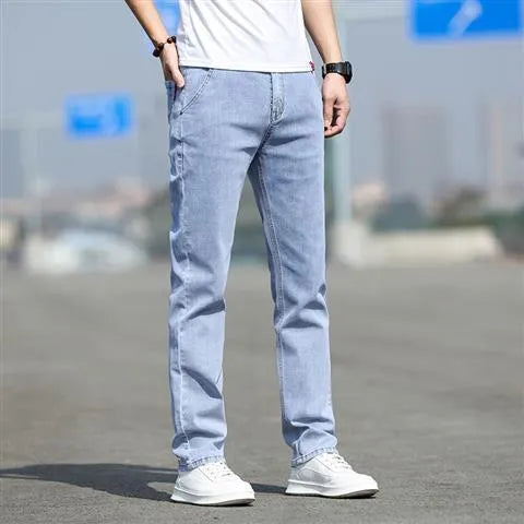 Man wearing smoky grey straight leg men's jeans with a low waist and zip fly.