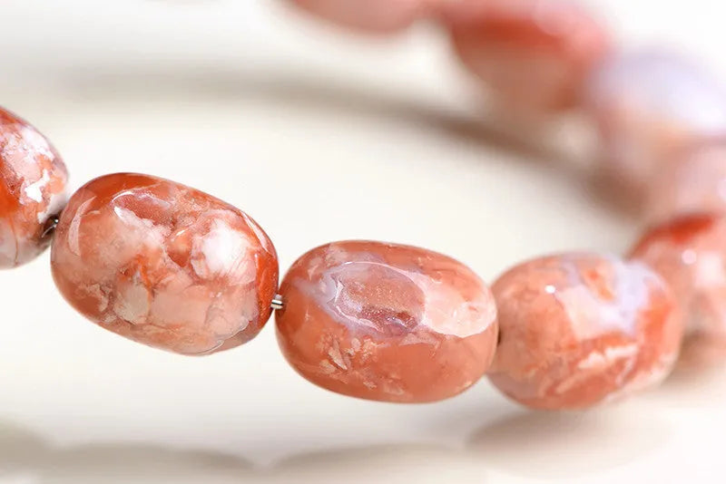 Natural cherry agate barrel bead bracelet with ruyi design elements measuring 10x14mm