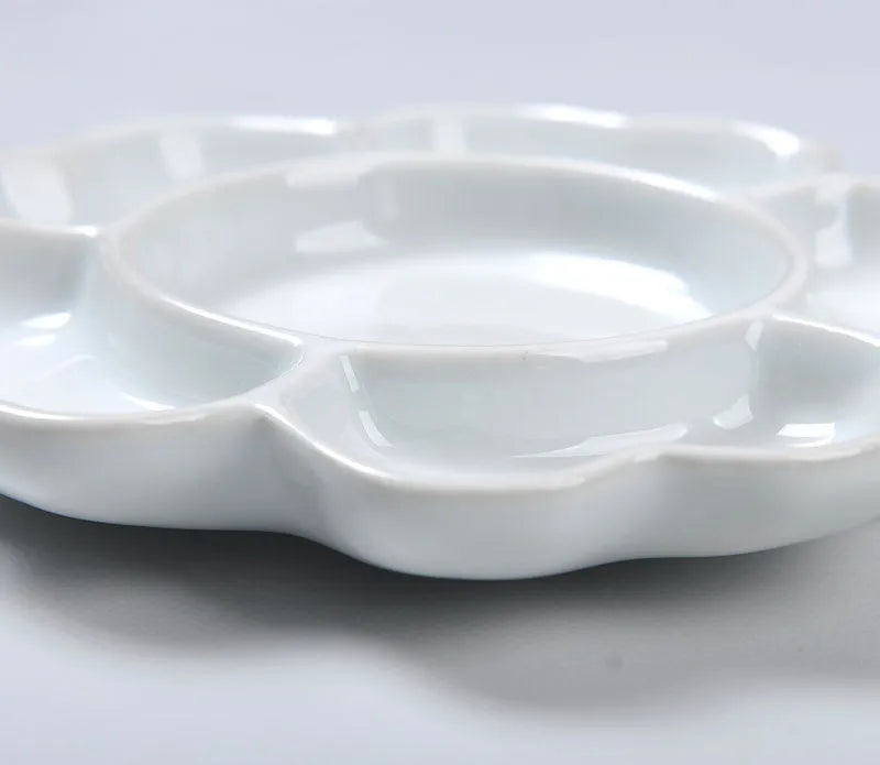 White ceramic plum blossom shaped artist's palette for paint mixing
