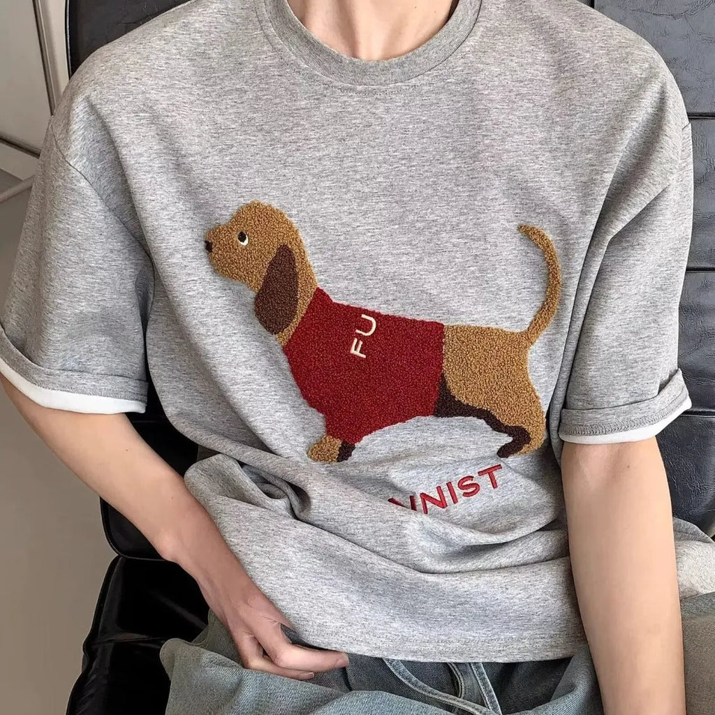Grey men's cotton T-shirt with an embroidered cartoon dachshund holding a towel.