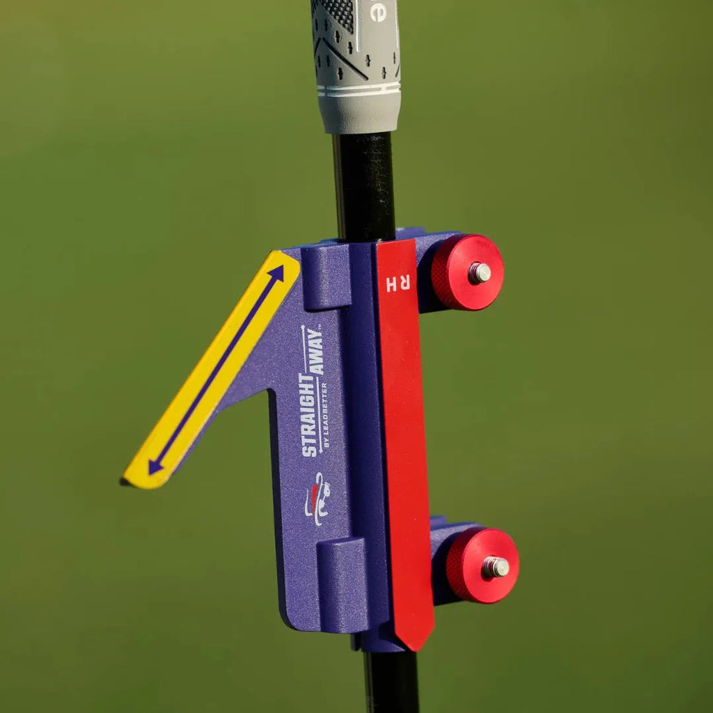 A plastic golf swing plane simulator training aid on a green background.