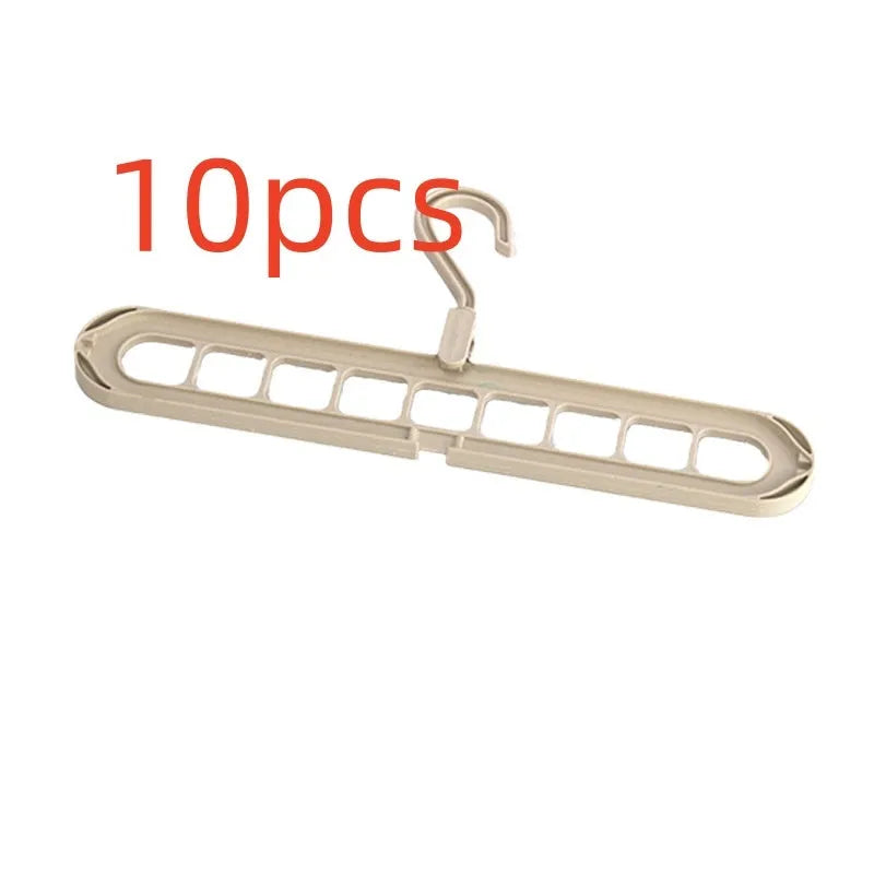 Green plastic multifunctional hanger with nine arms for folding trousers, shown hanging on a rail.