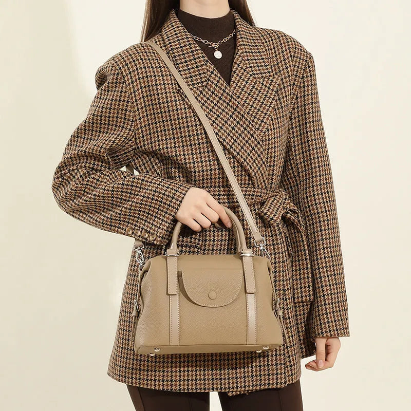 Genuine leather ladies handbag in black, brown, or elephant grey with contrast stitching and a lock.