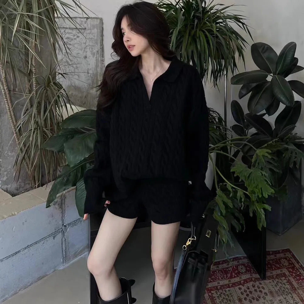 Women's knitted suit set showing geometric pattern cable knit sweater and elastic waist shorts in black colour