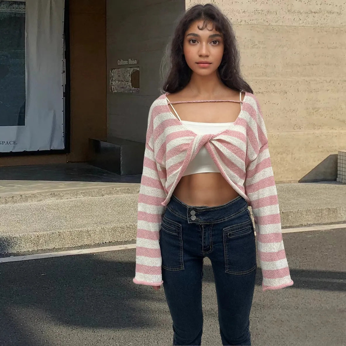 A striped long-sleeved pullover sweater with a cropped front and back design, shown in a selected colour.