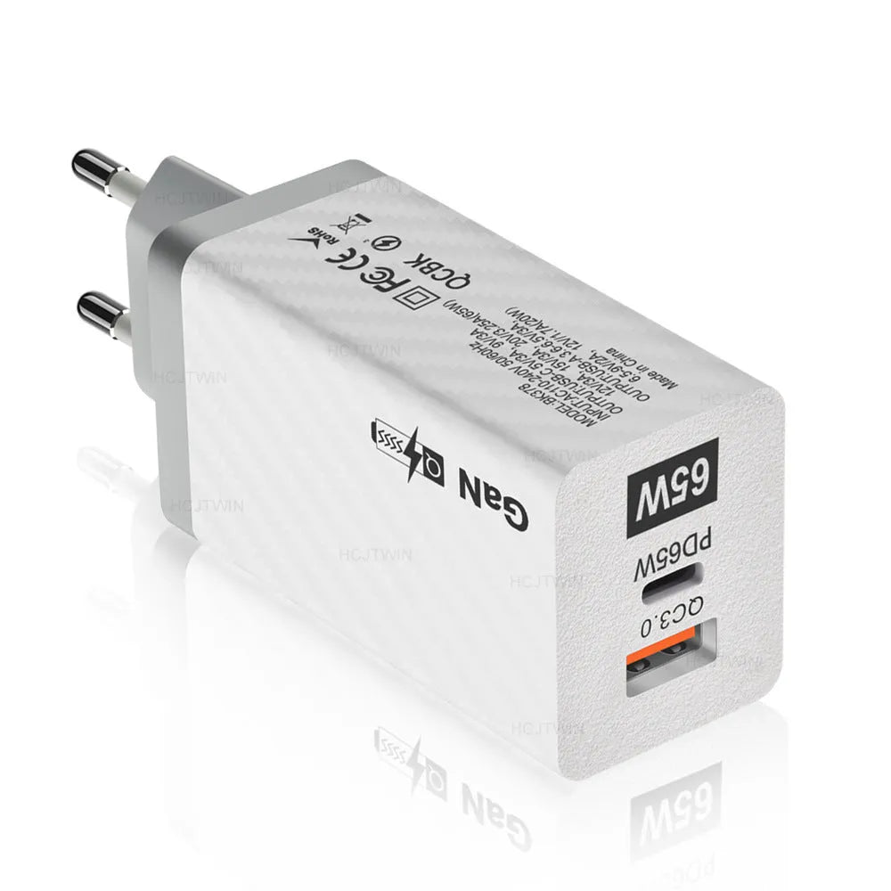 White 65W Gallium Nitride USB-C laptop charger with EU plug next to black version with US plug.