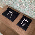 Women's black quilted computer bag with ballet bow detail showing striped nylon lining