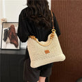 Knitted bucket-shaped tote beach bag with crossbody strap, shown in black, featuring contrasting stitching.