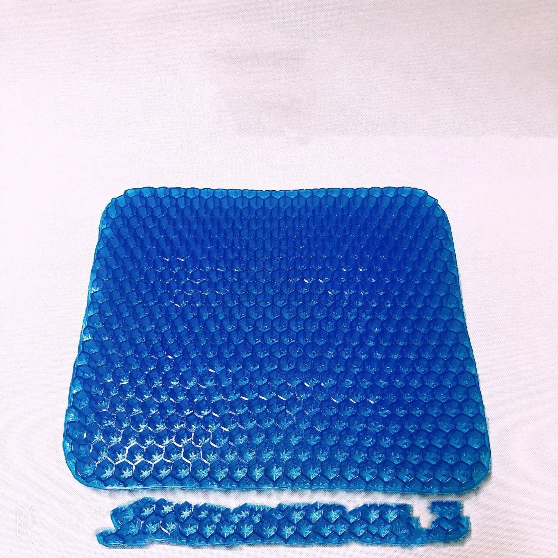 Grey honeycomb gel seat cushion with removable cover, shown on a wooden chair.