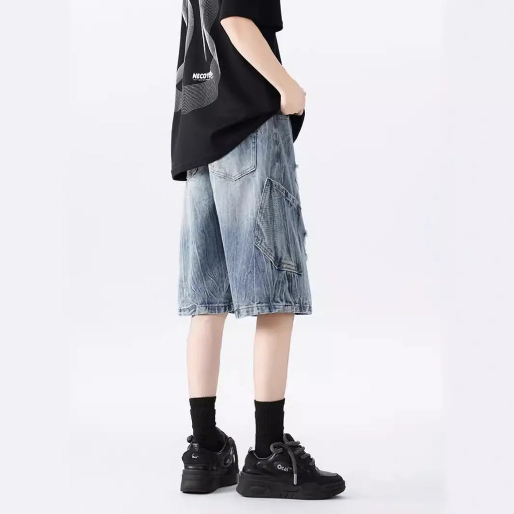 Man's ripped and washed vintage blue denim shorts with a loose, retro fit