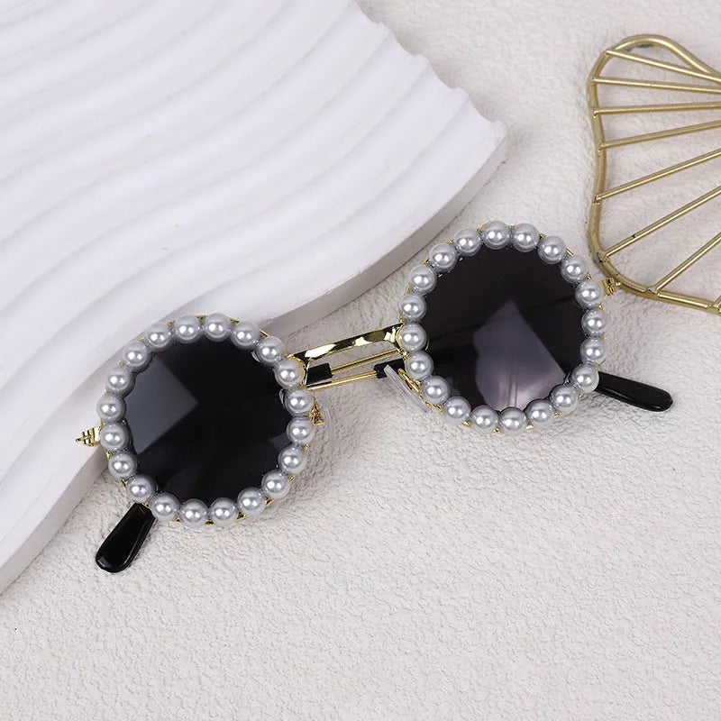 Pearl-rimmed round sunglasses for a cat or dog on a festive background.