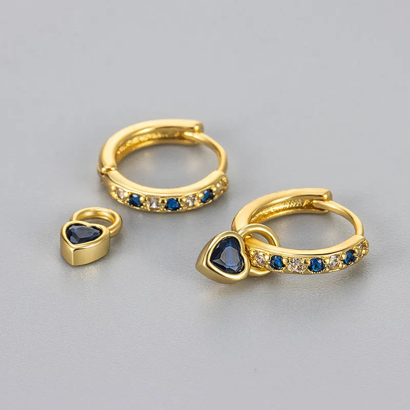 Women's fashion earrings with heart-shaped drops containing coloured gemstones in gold or white gold colour settings