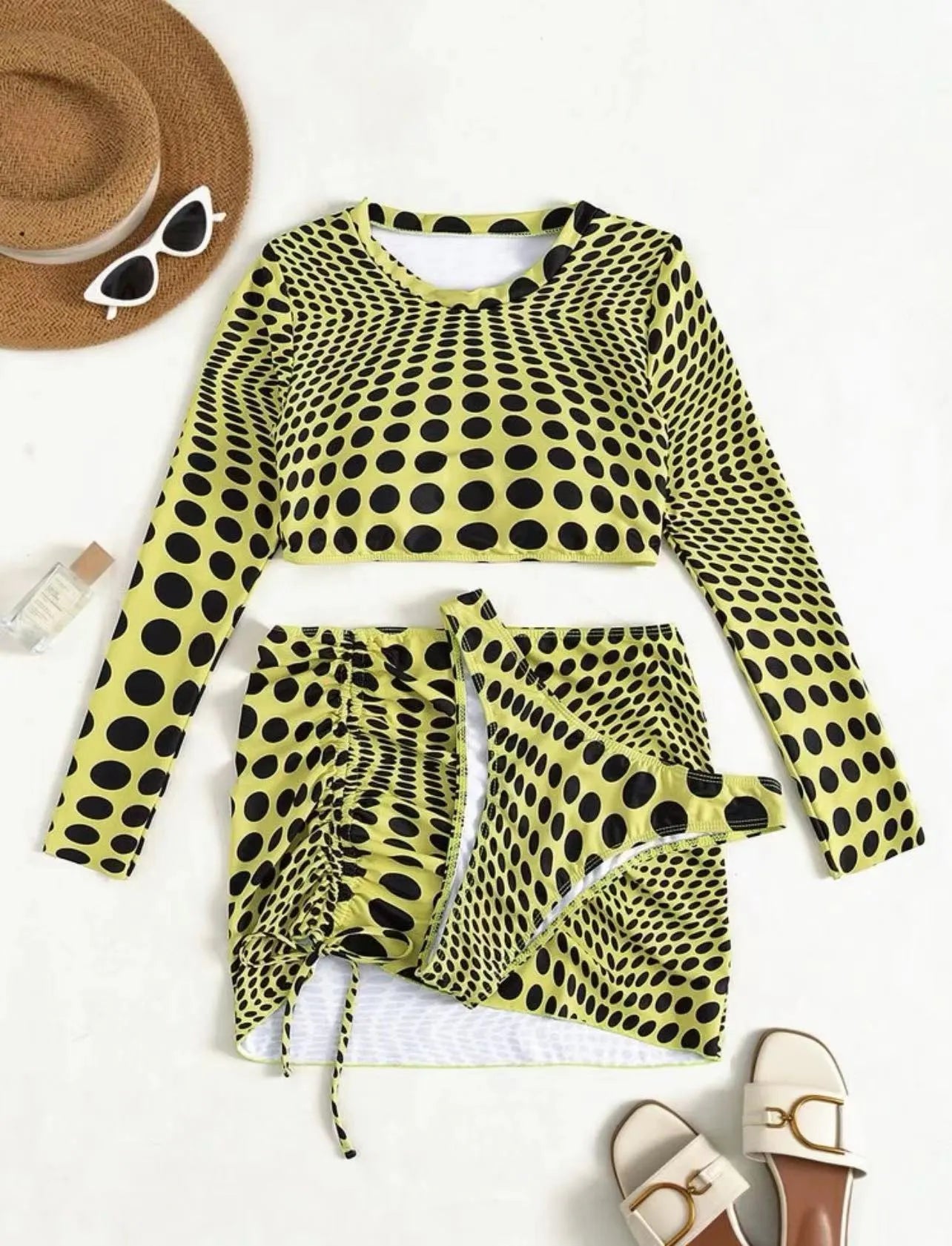 Women's green polka dot three-piece swimsuit set with bra top and skirt on hanger