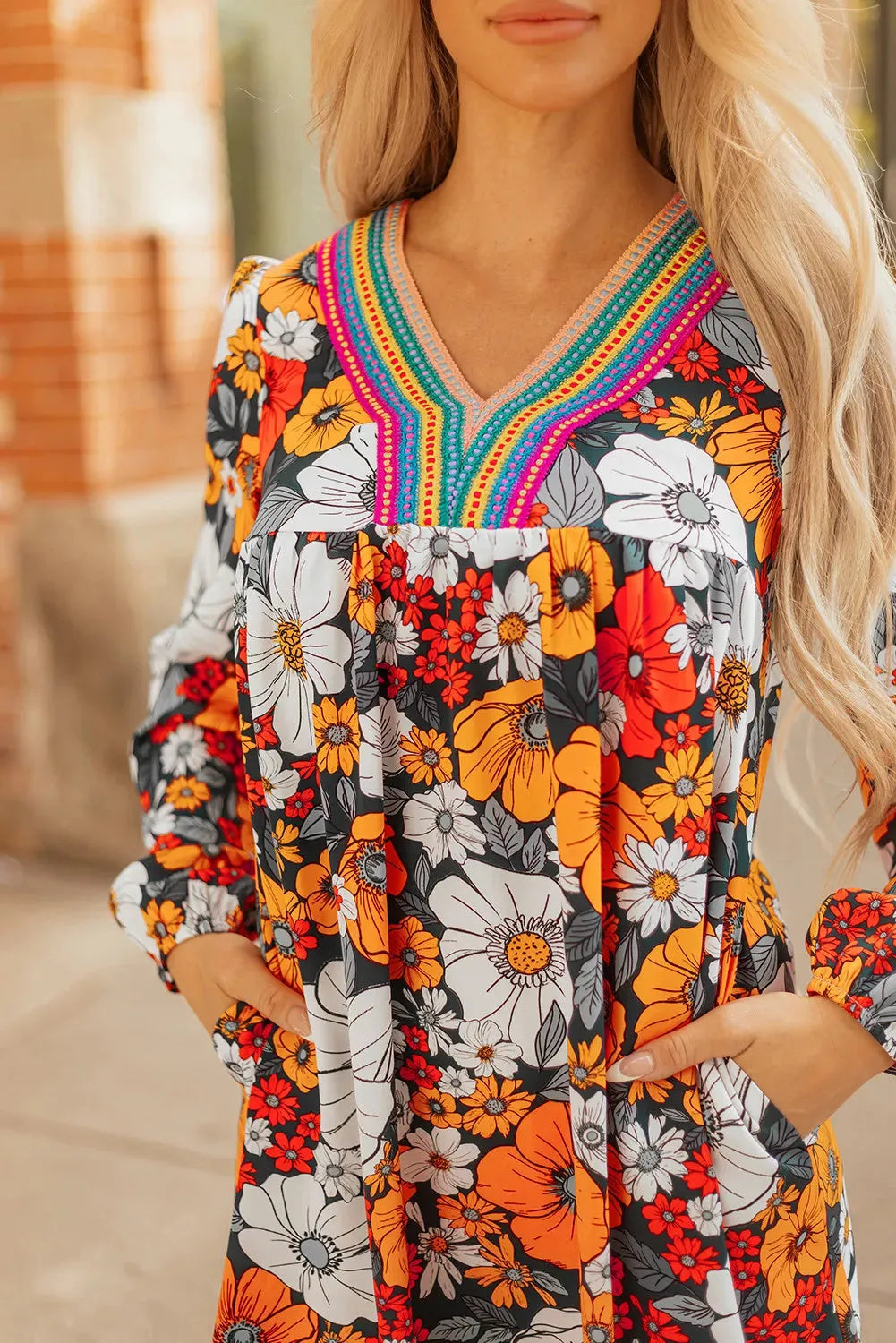 Orange women's mini dress with floral striped print and lace detailing, featuring a V neck and long sleeves.