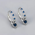 Women's fashion earrings with heart-shaped drops containing coloured gemstones in gold or white gold colour settings