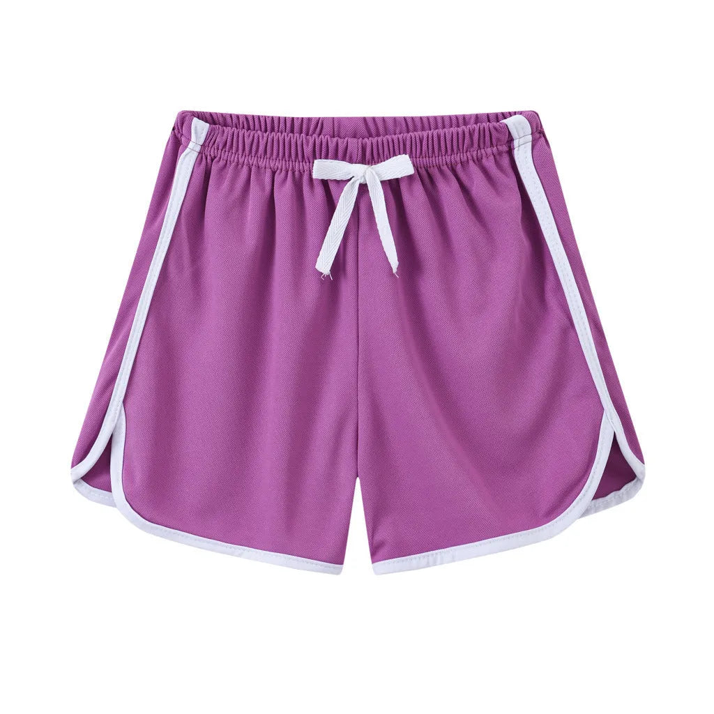 Children's patterned beach shorts in various colours including leopard print, floral, and fruit designs