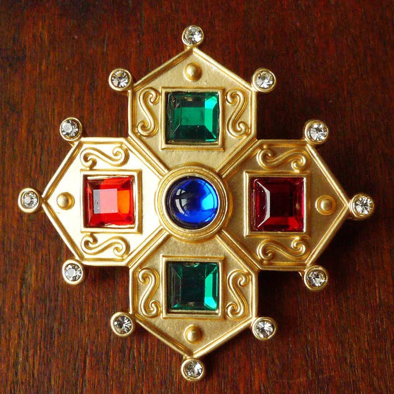 A vintage-style baroque brooch made of zinc alloy in a diamond shape on a fabric background.