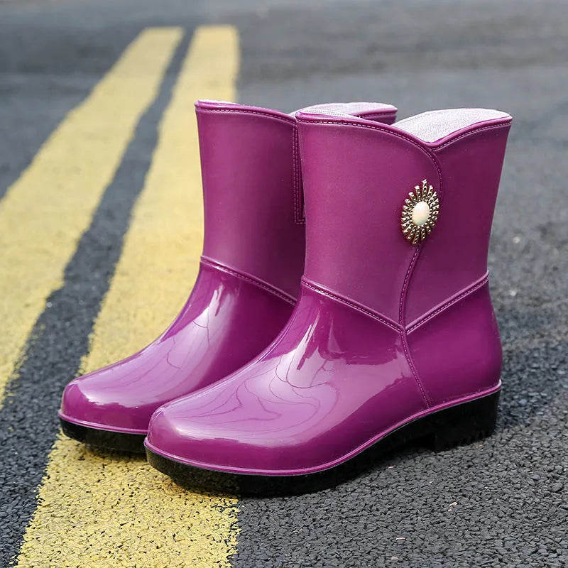 Women's purple rain boot with middle tube height and textured non-slip sole.