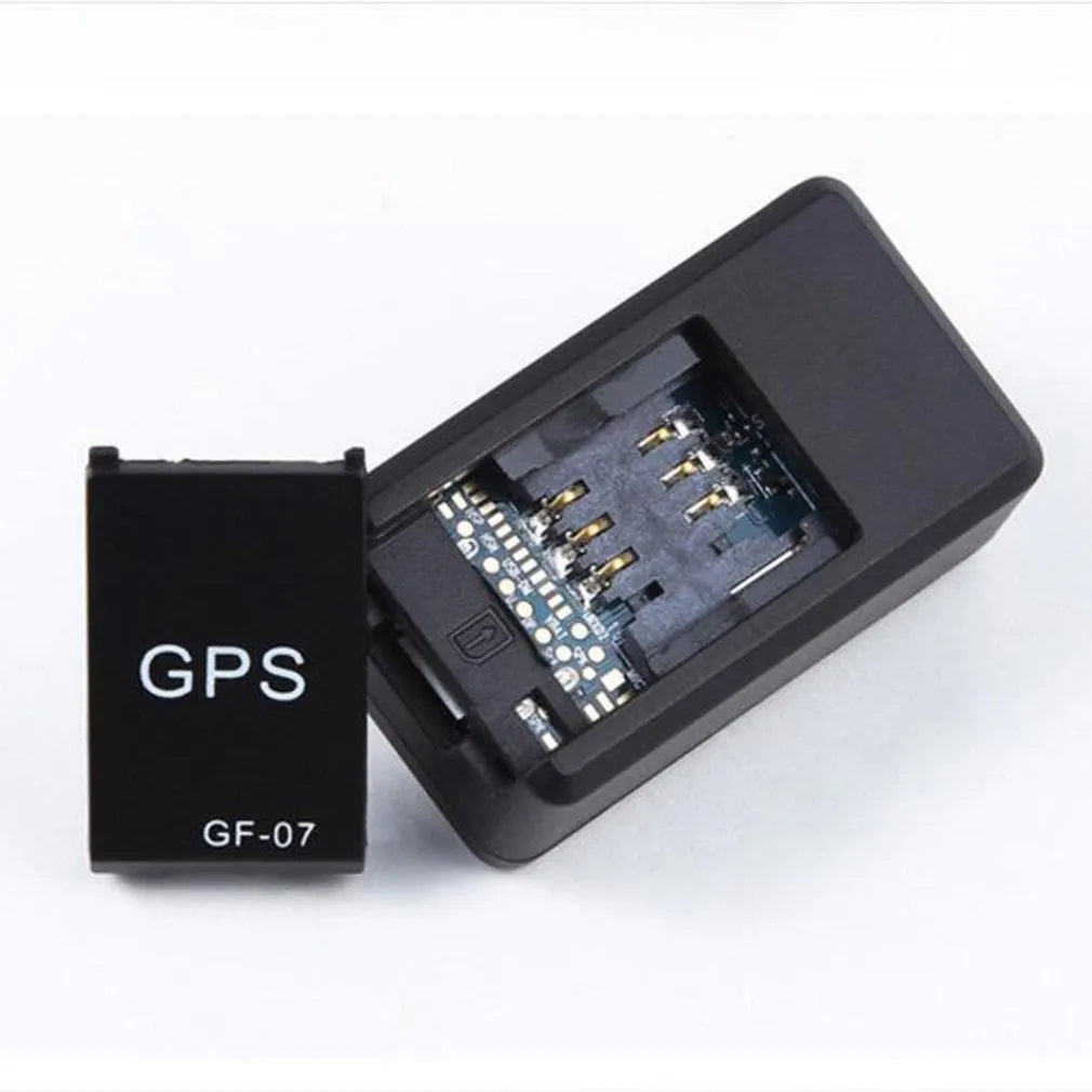 Small black plastic magnetic GPS car tracker device on a metal surface.