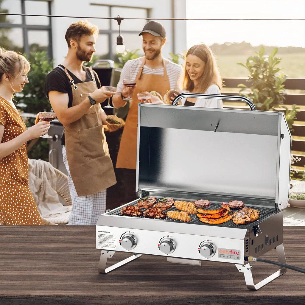 Silver stainless steel desktop gas barbecue grill with three burners and foldable legs